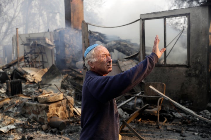 John Honigsfeld surveys the damage to a neighbor's property after a wildfire swept through Saturday, Nov. 10, 2018, in Malibu