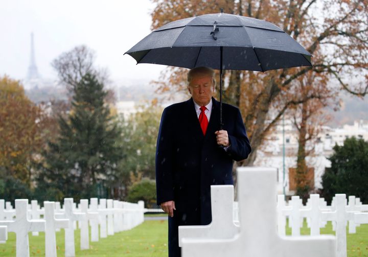 President Donald Trump stands among headstones during an American Commemoration Ceremony on Sunday at Suresnes American Cemetery near Paris, one day after skipping another World War I ceremony because of rain.