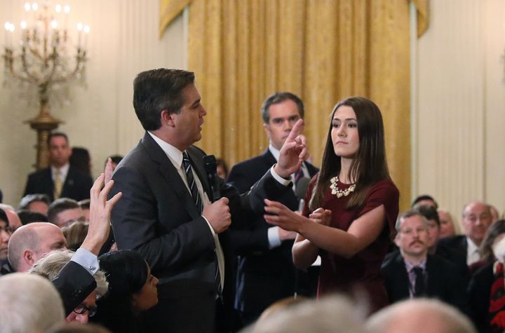 An intern moves to take the microphone from CNN's Jim Acosta during last week's press briefing. Later, the White House revoked Acosta's press pass.