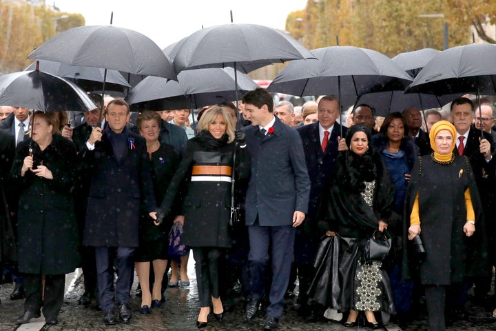 French President Emmanuel Macron's wife, Brigitte Macron (center left) listens to Canadian Prime Minister Justin Trudeau (center right) as they walk with world leaders toward the Arc de Triomphe in Paris on Sunday.