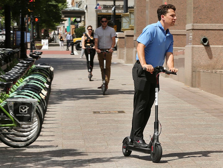 Mark Rodgers rides an electric scooter in Salt Lake City this summer. Cities and states are trying to figure out how to regulate dockless scooters and whether they should be allowed on streets, sidewalks or both. 