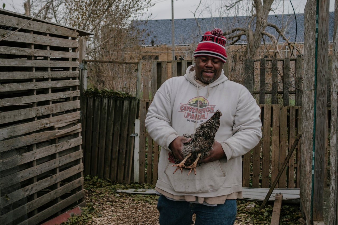 Mark Covington catches a chicken at the Georgia Street Community Collective on Nov. 12. In 2008, Covington started tending three vacant lots, turning them into a community garden to prevent illegal dumping.