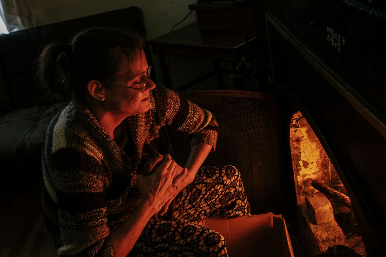 Fritz builds a fire using wood collected from the alley to heat her house.