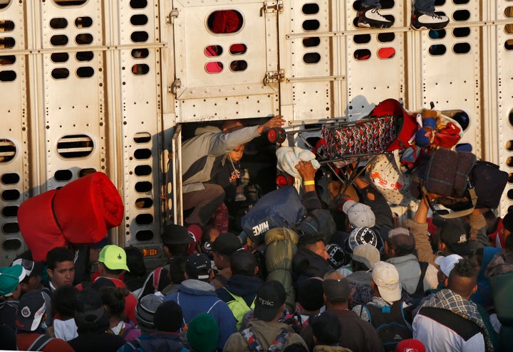 Central American migrants, part of the caravan hoping to reach the U.S. border, get a ride in a chicken truck, in Irapuato, Mexico, on Nov. 12, 2018. Several thousand Central American migrants marked a month on the road Monday as they hitched rides toward the western Mexico city of Guadalajara.