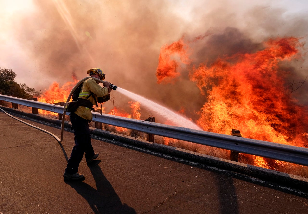 A firefighter battles a fire along the Ronald Reagan Freeway, aka state Highway 118, in Simi Valley, California, Nov. 12, 2018. 