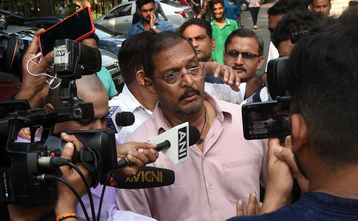 Indian Bollywood actor Nana Patekar is mobbed by the media as he leaves after making a statement outside his home in Mumbai on Oct. 8.