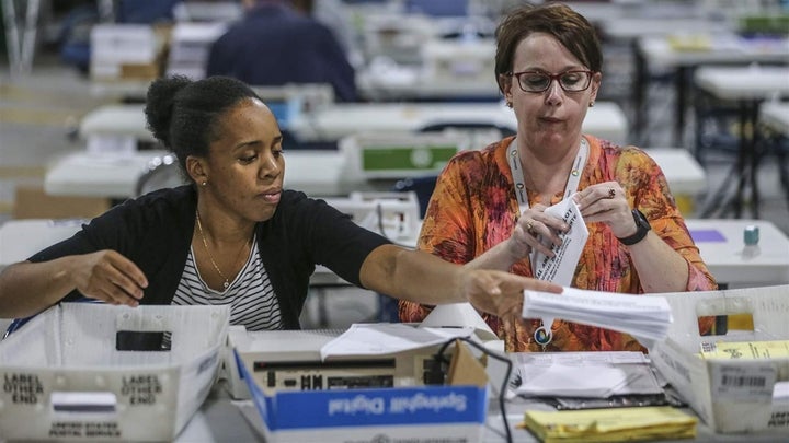 Election officials in Gwinnett County, Georgia, open and scan absentee ballots during the midterm election count. Untraditionally, absentee and provisional ballots played a major role in this election. 