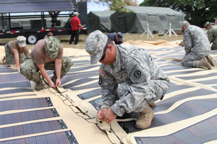 The U.S. Army is increasingly deploying solar power in the field. Above, soldiers assemble a solar shade canopy during a training exercise.