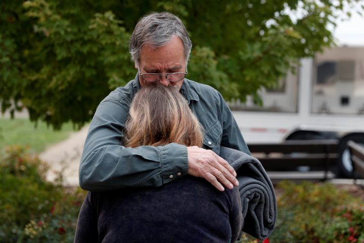 Lane Walker, of Magalia, comforts his wife, Julie, at an evacuation center for people displaced by the Camp Fire in Chico, California.