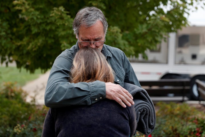 <strong>Lane Walker, of Magalia, comforts his wife, Julie, at an evacuation center for people displaced by the Camp Fire in Chico, California.</strong>