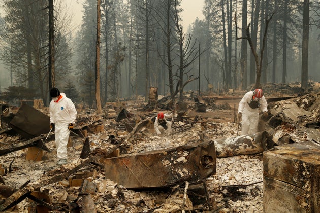 Search and rescue workers search for human remains at a trailer park burned by the Camp Fire in Northern
