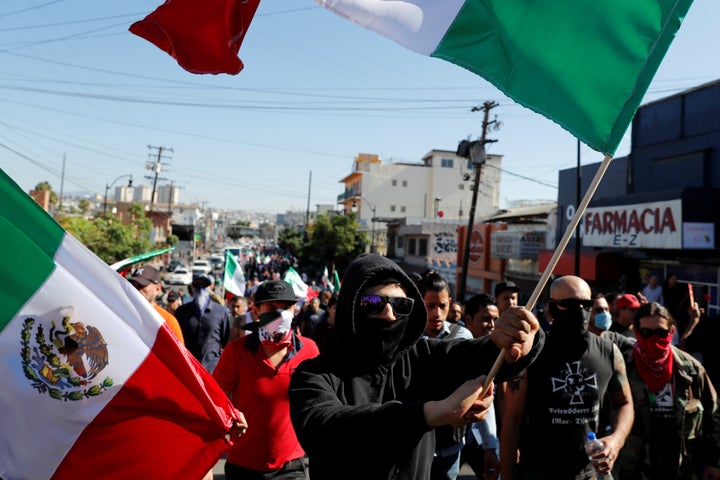Demonstrators wave Mexican flags during a protest against migrants who are part of a caravan traveling en route to the United