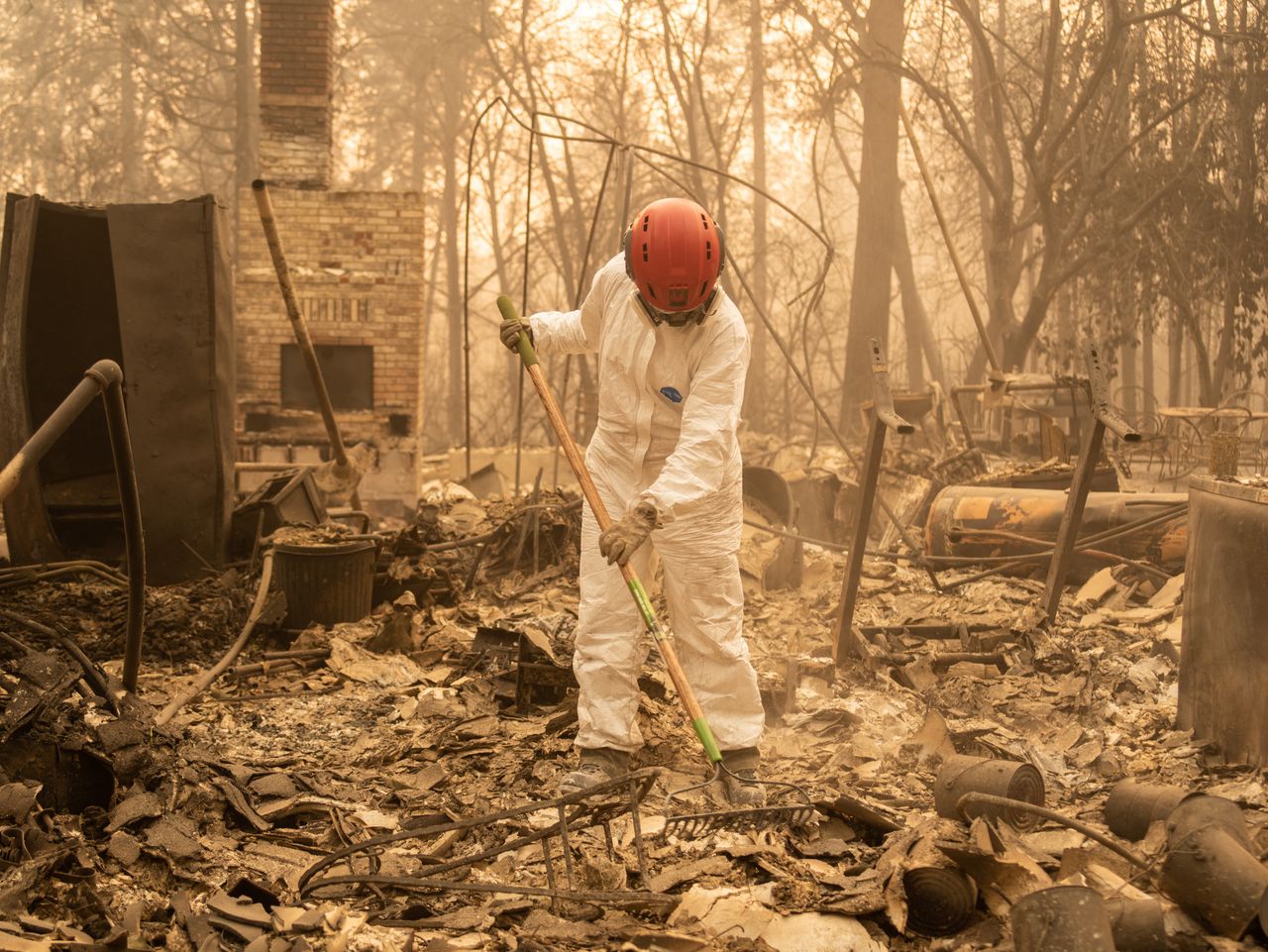 A member of the Tuolumne County Sheriff's Search & Rescue Team looks for human remains at a burned home in Paradise.