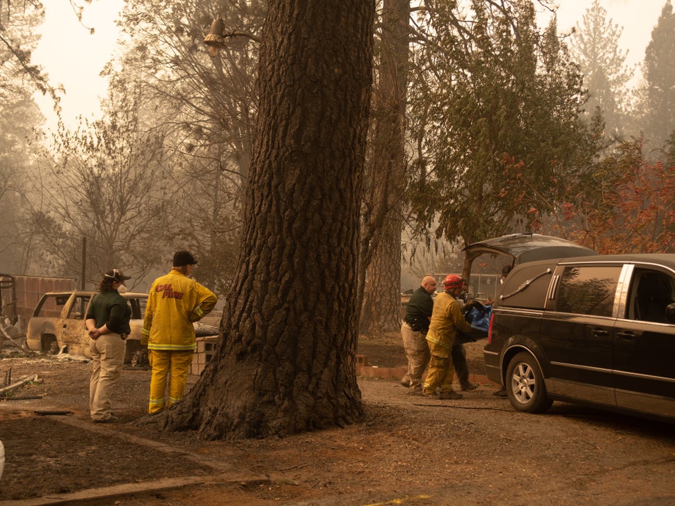 Cal Fire and police teams transfer the remains of a fire victim, who was found in a Paradise, California, residence, into a h