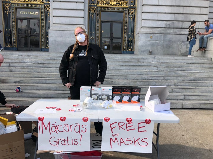 A member of the Democratic Socialists of America distributes masks outside City Hall in San Francisco.