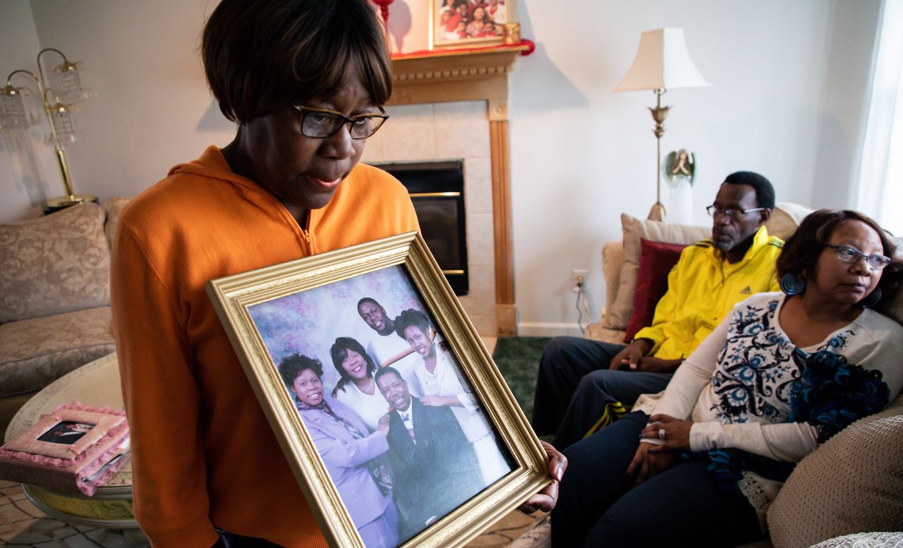 The mother of Tamara O'Neal holds a picture of her family, Nov. 20. O'Neal was fatally shot by her former fiance in Chicago the day before.