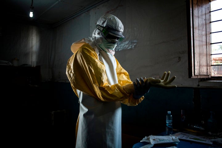 A health worker puts on protective equipment before entering the red zone of a Doctors Without Borders-supported Ebola treatment center earlier this month.