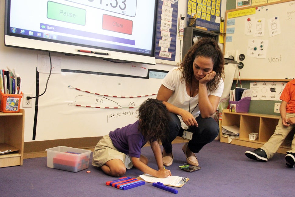 Mott Haven Academy Charter School teacher Carolina Garcia helps one of her first-grade students with an assignment. At Haven,
