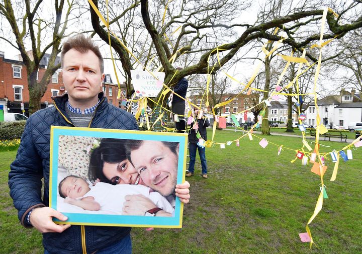 Richard Ratcliffe holding a picture of his wife and daughter