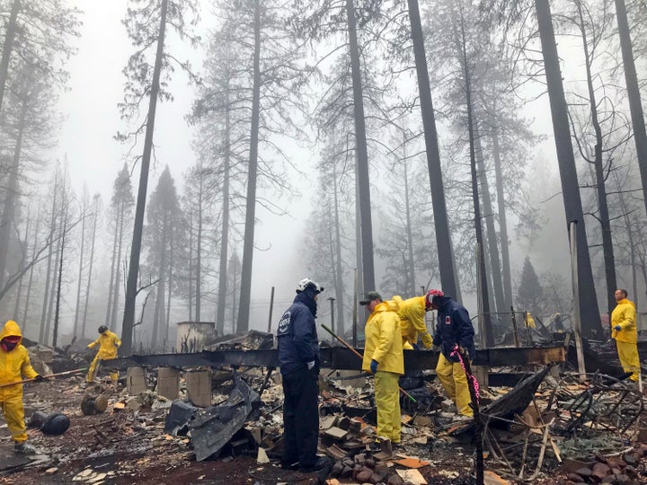 After a brief delay to let a downpour pass, volunteers resume their search for human remains at a mobile home park in Paradise, Calif., on Friday, Nov. 23, 2018.