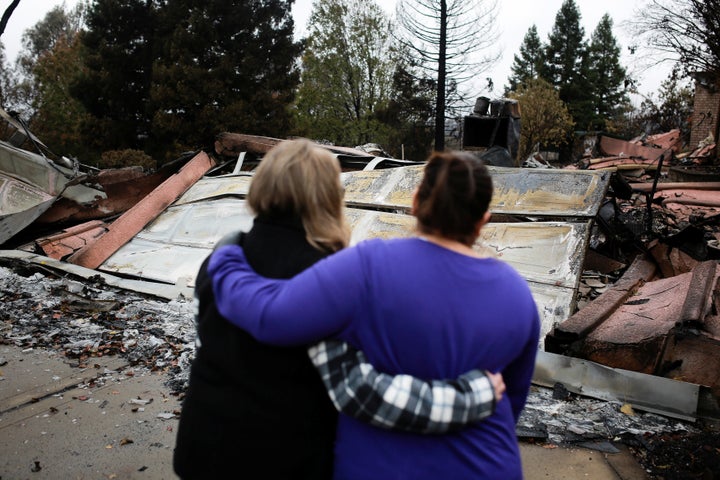 Irma Corona (R) comforts neighbor Gerryann Wulbern in front of the remains of Wulbern's home after the two returned for the first time since the Camp Fire in Paradise, California, on Thursday, Nov. 22, 2018.