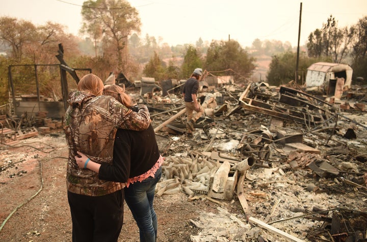 Kimberly Spainhower hugs her daughter Chloe, 13, while her husband Ryan Spainhower searches through the ashes of their burned home in Paradise, California, on Nov. 18. A new report from 13 federal agencies has connected extreme weather events, such as wildfires, to climate change. 