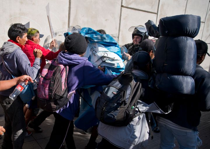 Migrants push past Mexican police at the Chaparral border crossing in Tijuana on Sunday as they try to reach the U.S. Tijuana's mayor has declared a humanitarian crisis in his border city and says that he has asked the United Nations for aid.