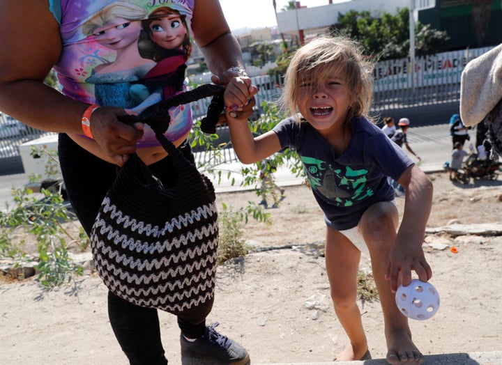 A Honduran toddler in diapers who came to the border on the migrant caravan sobs after she and her mother fled tear gas fired by American officers at the Mexican border Sunday.