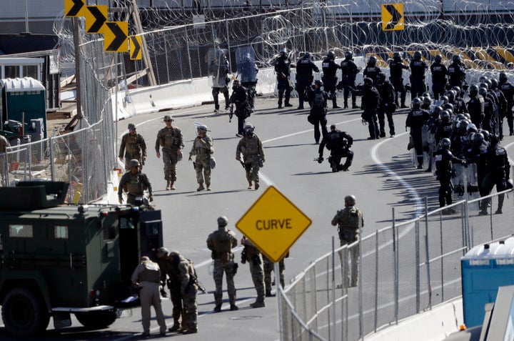 Military personnel and Customs and Border Protection officers gather along the southbound lanes of the San Ysidro port of entry Sunday, Nov. 25, 2018, in San Diego. (AP Photo/Gregory Bull)