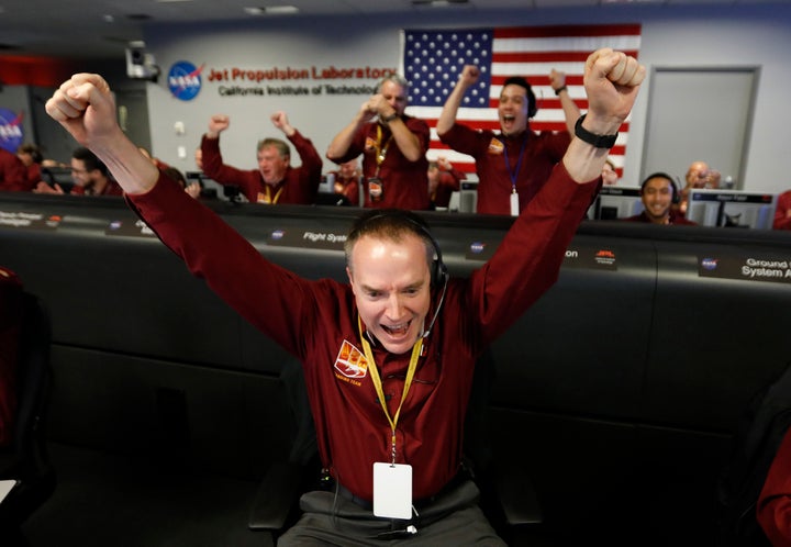 Engineer Kris Bruvold, bottom center, celebrates as the InSight lander touch downs on Mars.