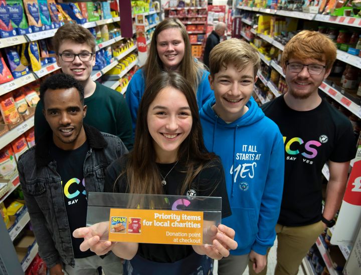 Abdel Kader, Matthew Turner, Amber Broad, Isabel Clarkson, Callum Pardoe and Rhys Johnson place a new sign next to a priority item at Sainsbury's in Exeter.