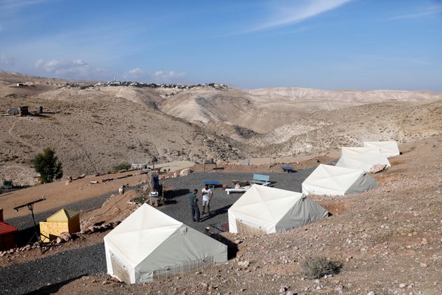 David Davidson, owner of Khan Eretz Ha'Mirdafim resort, chats with a worker at the camp near Alon settlement in the occupied West Bank 