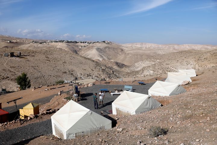 David Davidson, owner of Khan Eretz Ha'Mirdafim resort, chats with a worker at the camp near Alon settlement in the occupied West Bank 