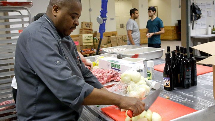 <p>A kitchen worker chops vegetables at the Waldorf Astoria resort at Disney World in Orlando. Sun Belt cities are attracting more people, but many of them are working in low-wage jobs.</p>