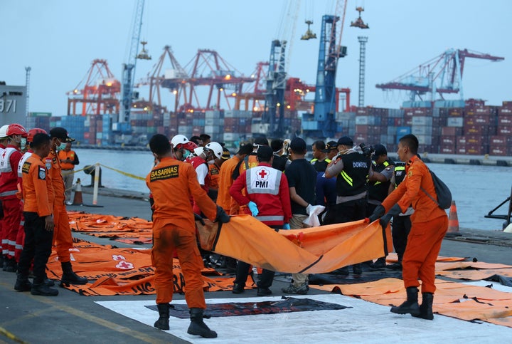 Officials examine victims recovered from the Lion Air jet that crashed into Java Sea on Monday at Tanjung Priok Port in Jakarta, Indonesia, Sunday, Nov. 4, 2018.