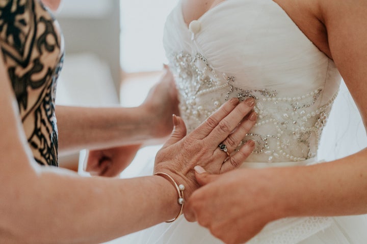 In this close-up shot, Agnew's mother uses her hands to feel the beading on the bodice of her daughter's wedding gown.