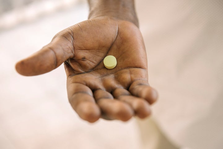 Dr. Victor Kande holds a single fexi pill. The drug is a dramatically simpler treatment for sleeping sickness.