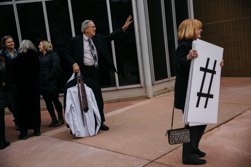 Gary Benjamin holds extra clothes for detained asylum-seeker Ansley Damus while Benjamin's wife, Melody Hart, carries a serie