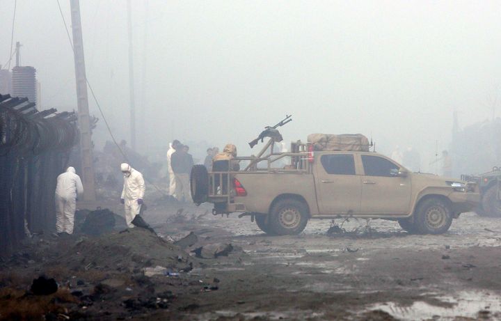 Security forces inspect the site of the suicide bomb attack.