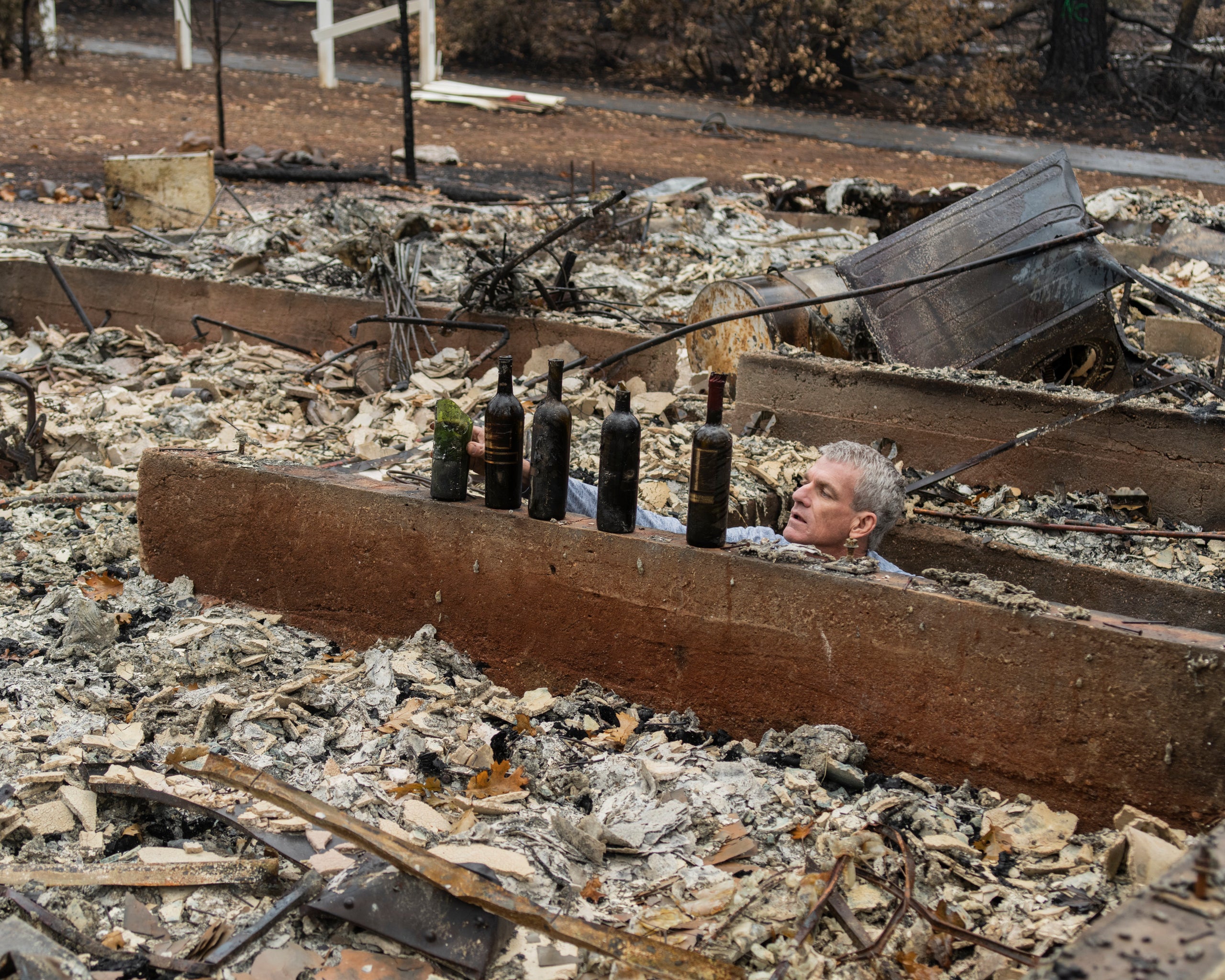 Robert Bean looking through his destroyed wine cellar.