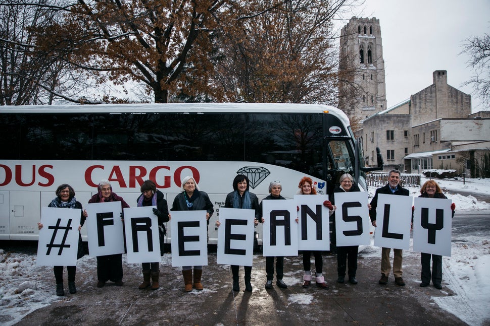 Riders showcase their #FREEANSLY signs before the bus ride from Saint Paul's Episcopal Church in Cleveland Heights, Ohio, to