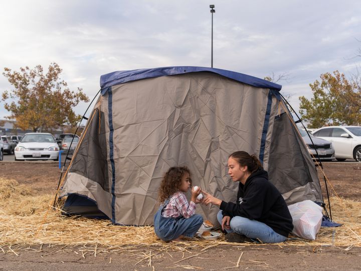 Rubyjade Stewart and her son, Rene, eat lunch at their tent in the Walmart lot on Wednesday between rain showers. By Thursday afternoon, there were flash flood and mudslide warnings in the area.