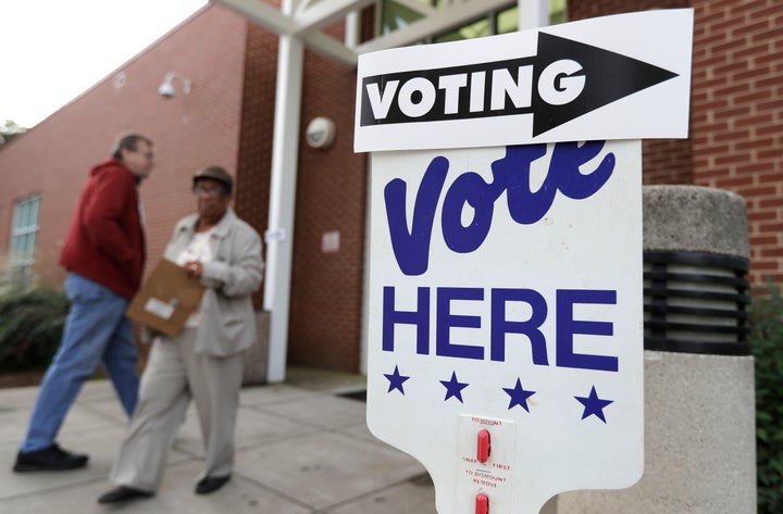 A voter arrives as a poll worker walks past during early voting in Charlotte, North Carolina, on Oct. 23, 2018. 