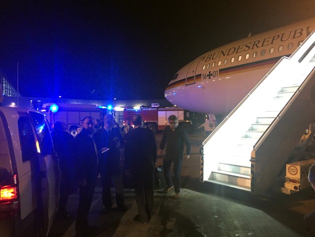 Menschen versammeln sich nach einer Notlandung auf dem Rollfeld des Kölner Flughafens um den Airbus