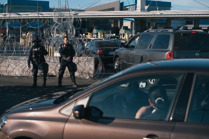 U.S. Customs and Border Protection officers observe vehicles standing in line at the San Ysidro port of entry in Tijuana, Mex