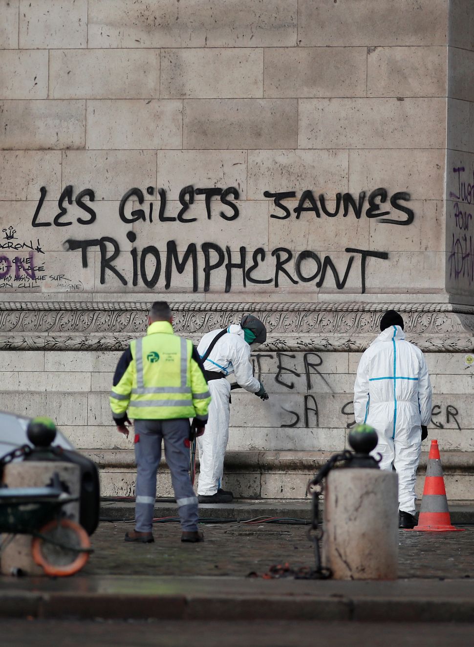 Professional cleaners begin to scrub graffiti from a monument in central Paris on Sunday.