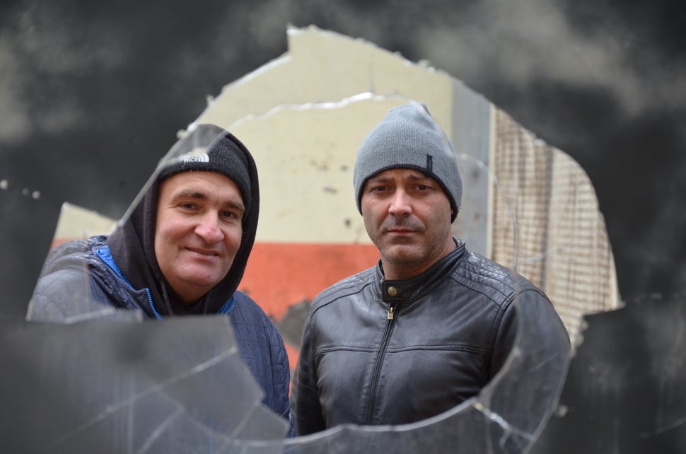 Miners Salvador&nbsp;Osario and Omar Garcia Alvarez look through a window in derelict mine.