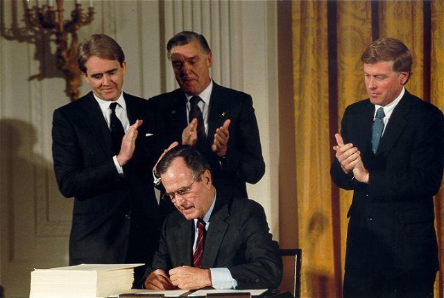 Former EPA Administrator William Reilly watches as the late President Bush signs the Clean Air Act Amendments on Nov. 15, 1990.