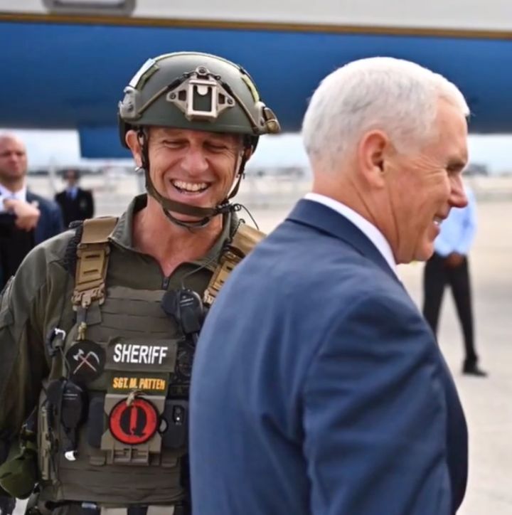 Matt Patten, wearing a QAnon patch as Vice President Mike Pence walks by.