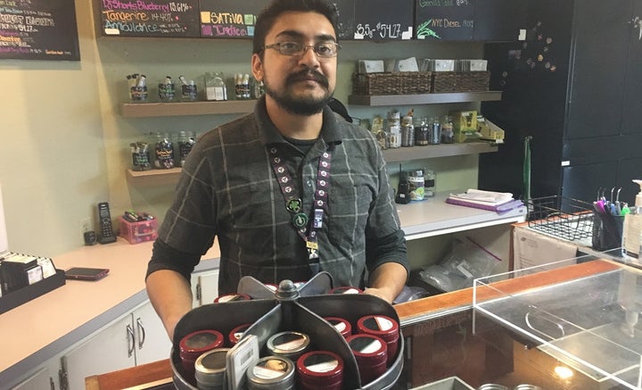 Budtender Rico Vasquez stands behind a counter displaying recreational pot products for sale at Smokey’s: A 4:20 House in Garden City, Colorado. Sales at marijuana dispensaries have created a tax revenue bonanza for the tiny town. 